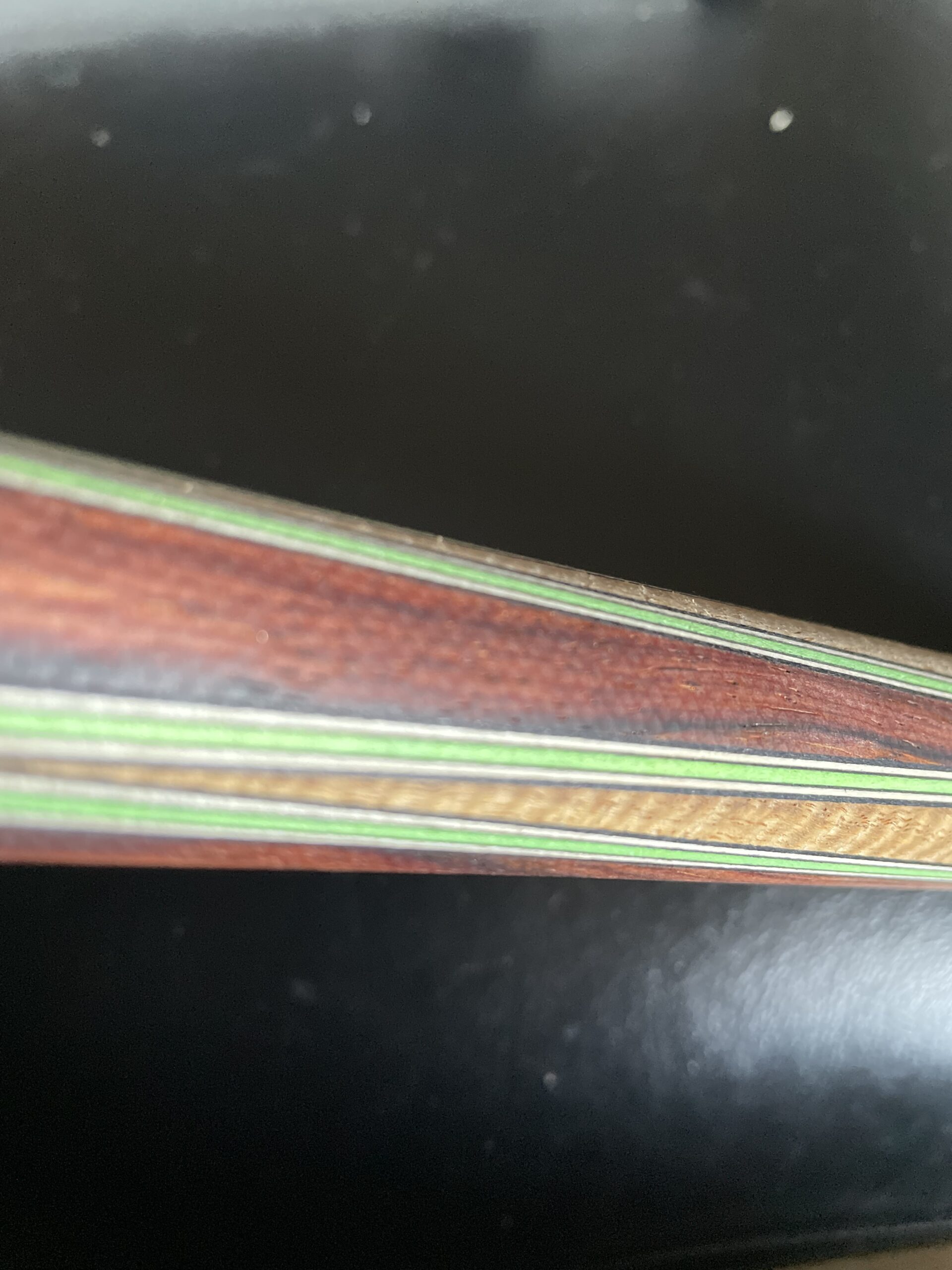 Close-up of dyed veneer accent lamination with green pinstripes